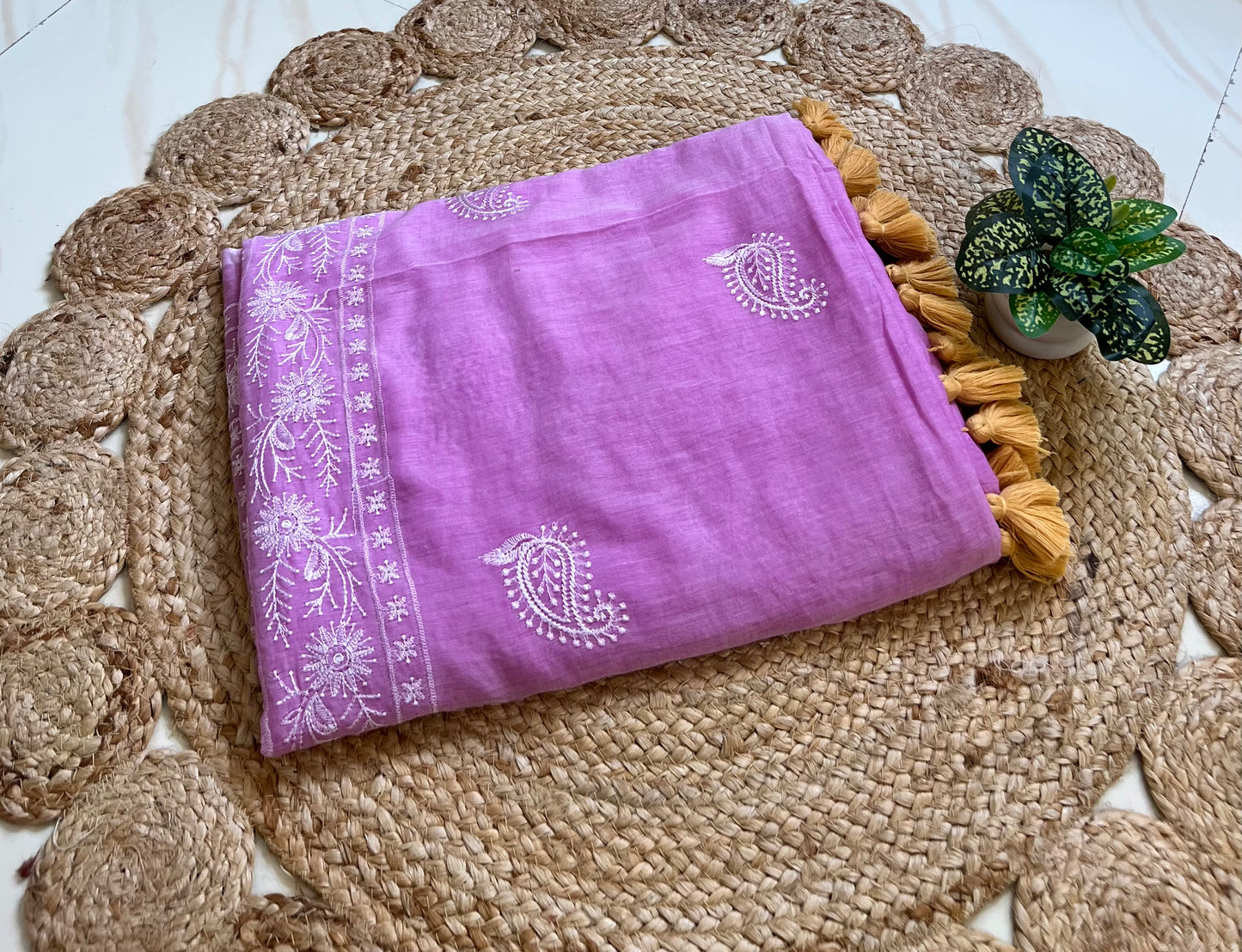 Lilac mul cotton saree with chikankari-style embroidery, neatly folded