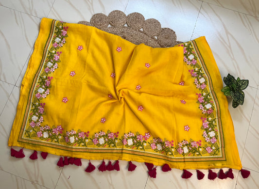 Close-up of pink and white embroidered floral pallu border with tassels on yellow mul cotton saree