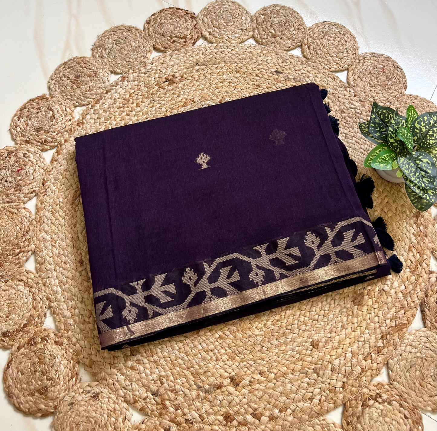 Folded royal purple cotton jamdani sari showing woven border and motifs