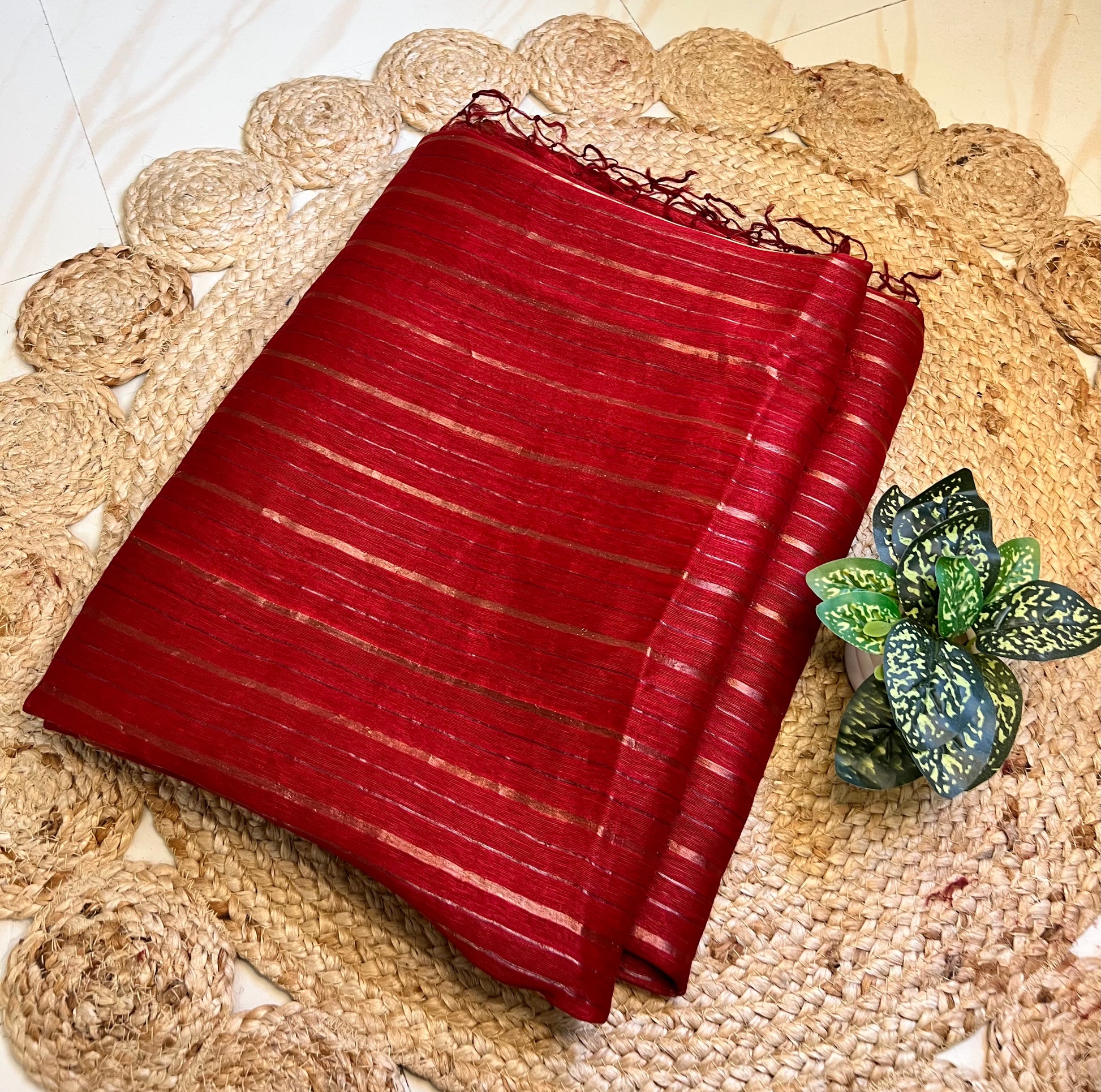 Close-up of gold zari stripes on red pure linen silk saree
