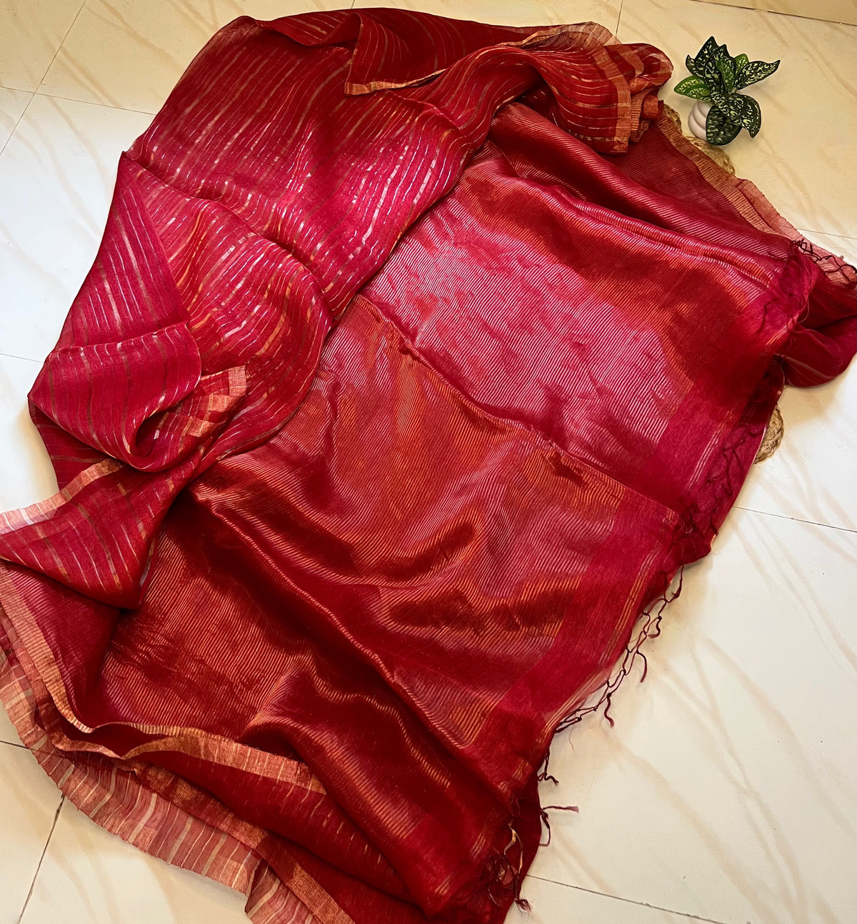 Pallu or tassels: Red linen silk saree pallu with tassels and gold zari stripes
