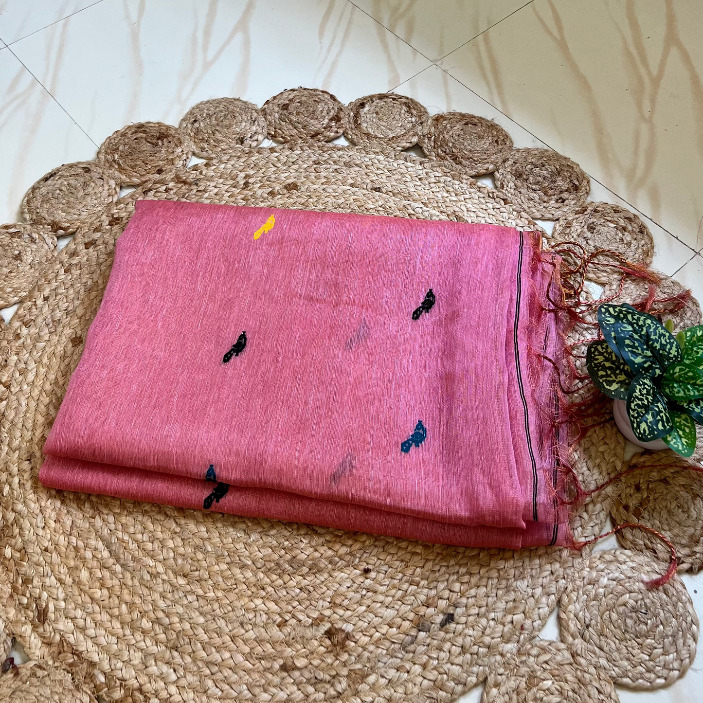 Close-up of bird motifs on baby pink handloom linen silk saree