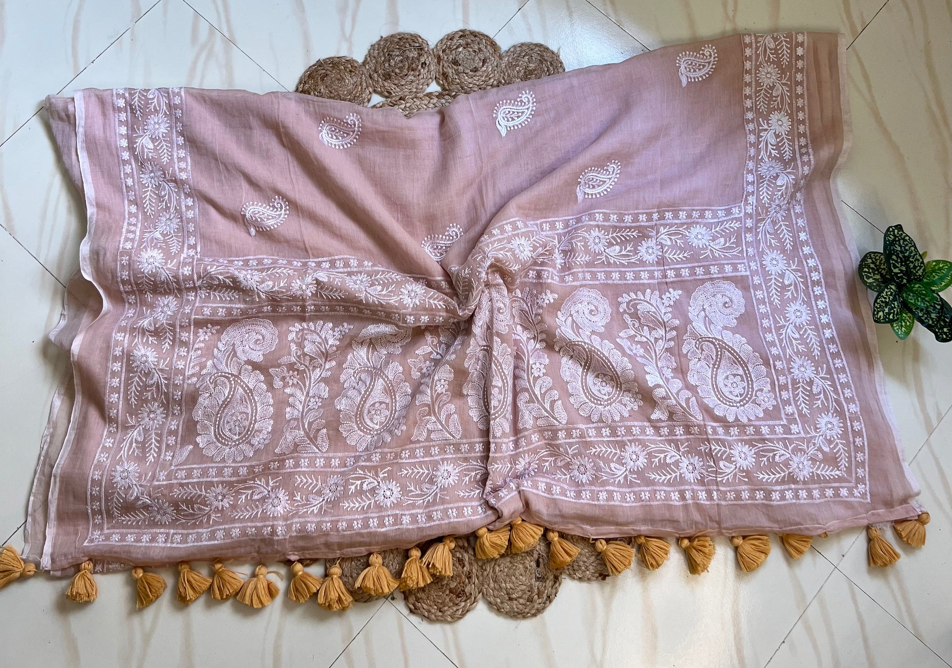 Close-up of white chikankari-style embroidered pallu border on dusty peach mul cotton saree
