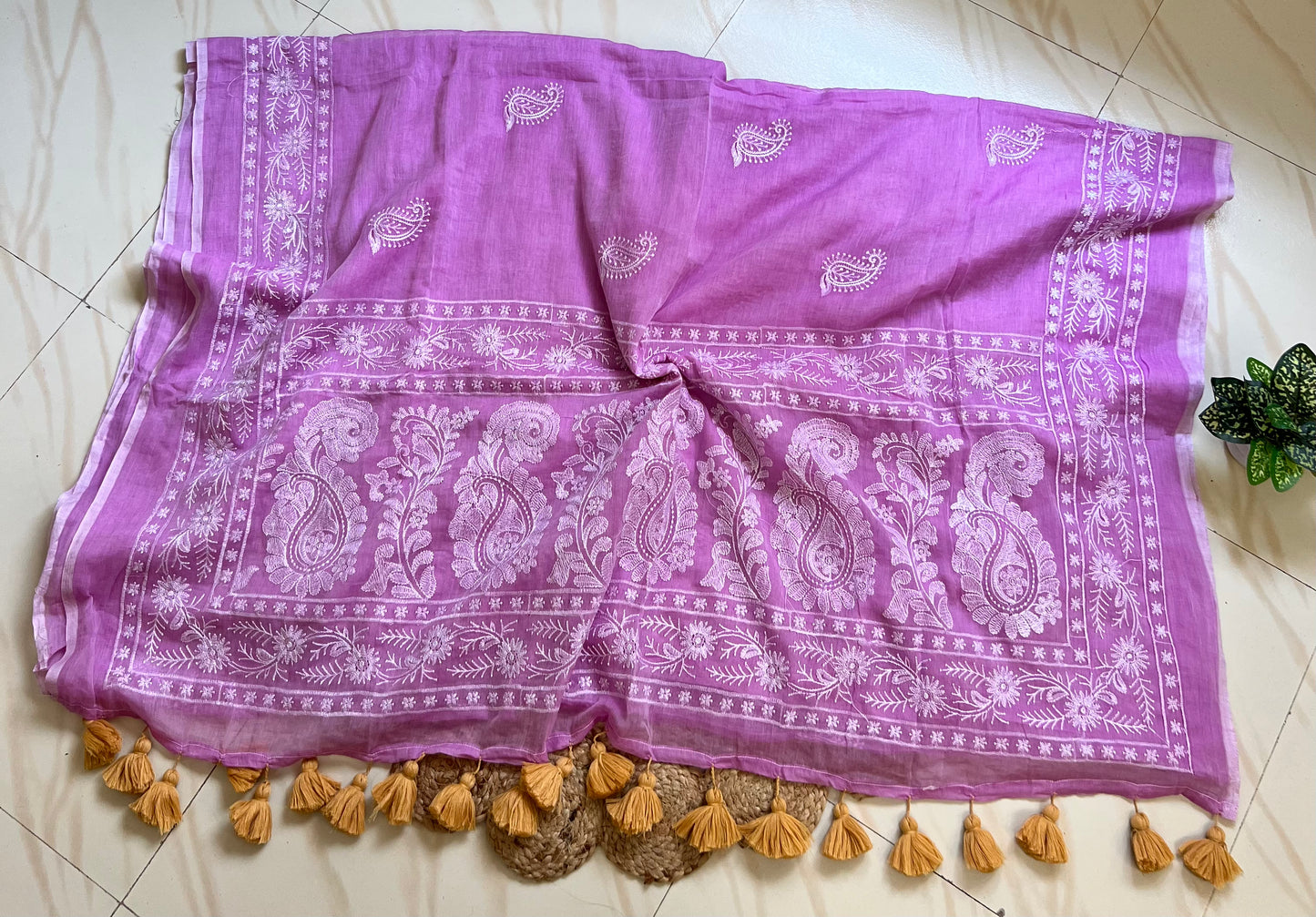 Close-up of white chikankari-style embroidered pallu border on lilac mul cotton saree