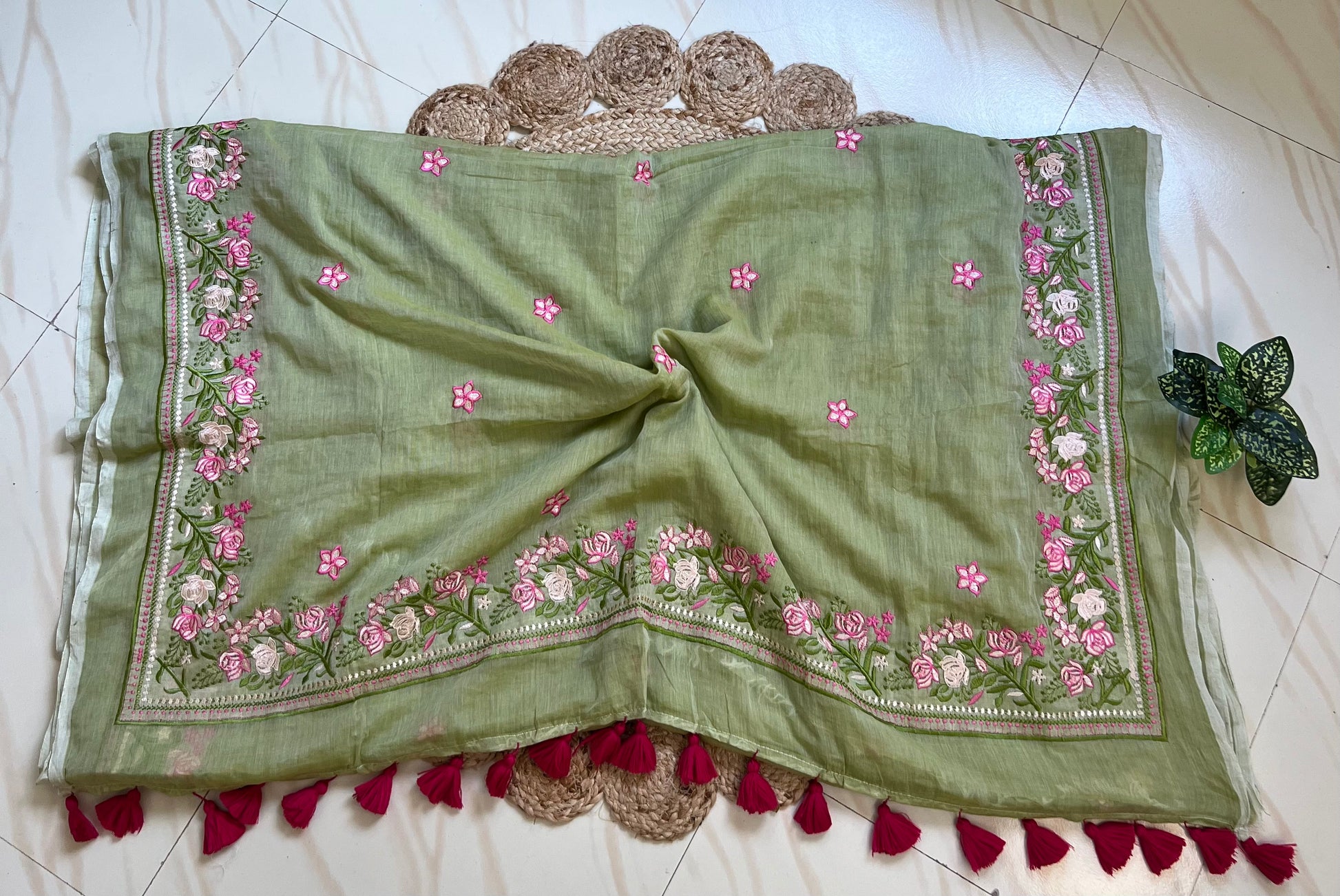 Close-up of pink hand-embroidered floral pallu border on pista green mul cotton saree
