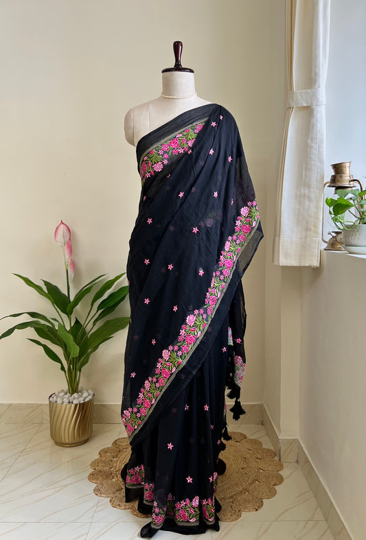 Black mul cotton saree with pink floral hand-embroidered border, draped on mannequin