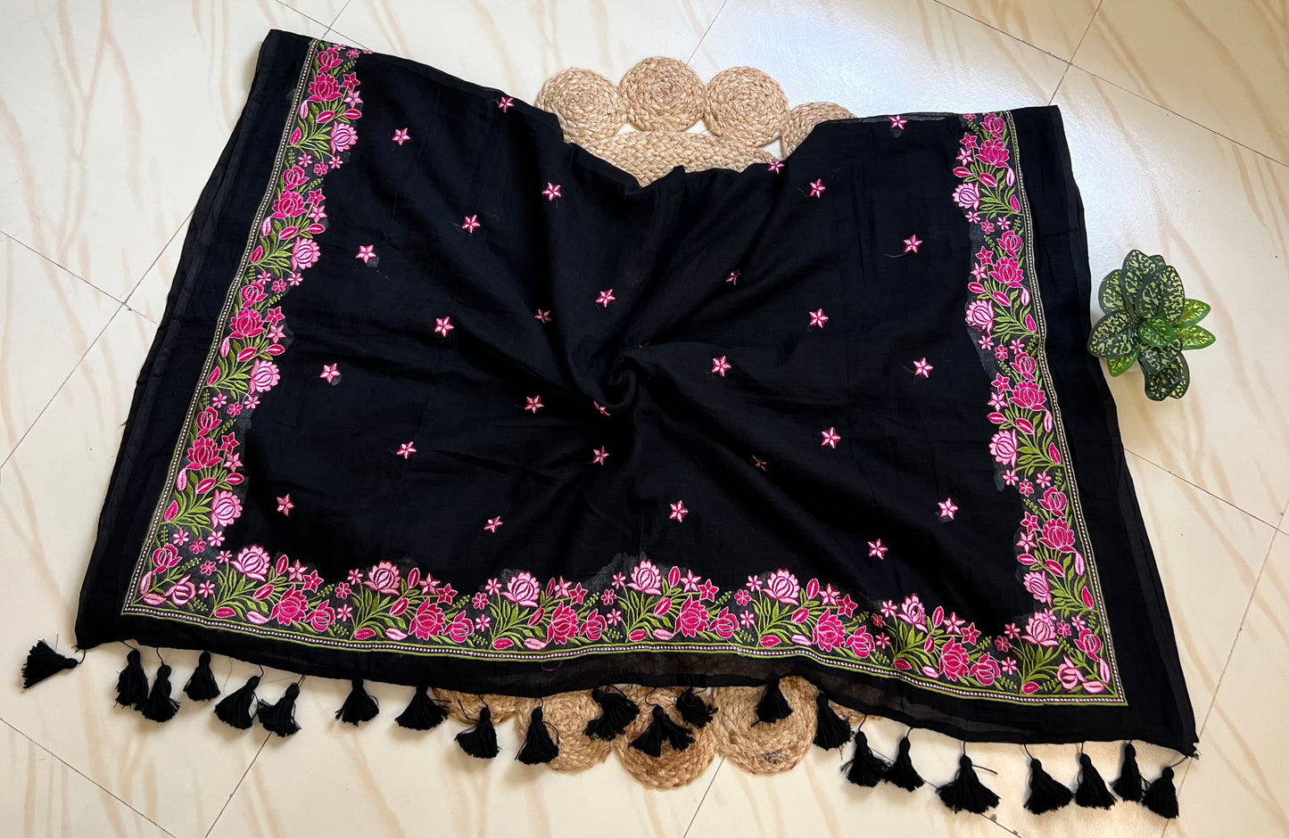 Close-up of pink floral hand-embroidered pallu on black mul cotton saree
