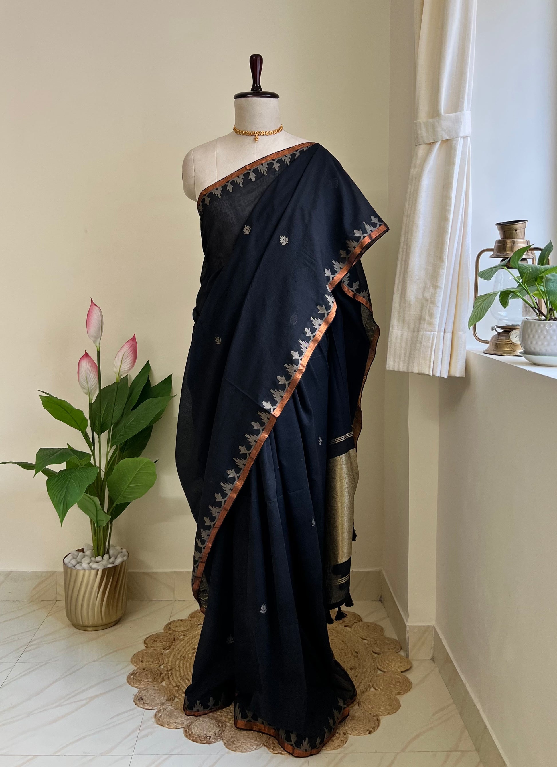 Classic black pure cotton jamdani saree with copper zari border and pallu, draped on mannequin