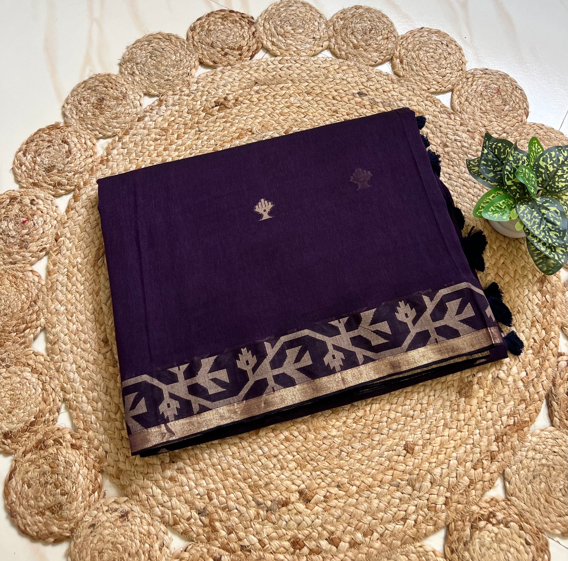 Folded royal purple cotton jamdani sari showing woven border and motifs