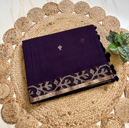 Folded royal purple cotton jamdani sari showing woven border and motifs