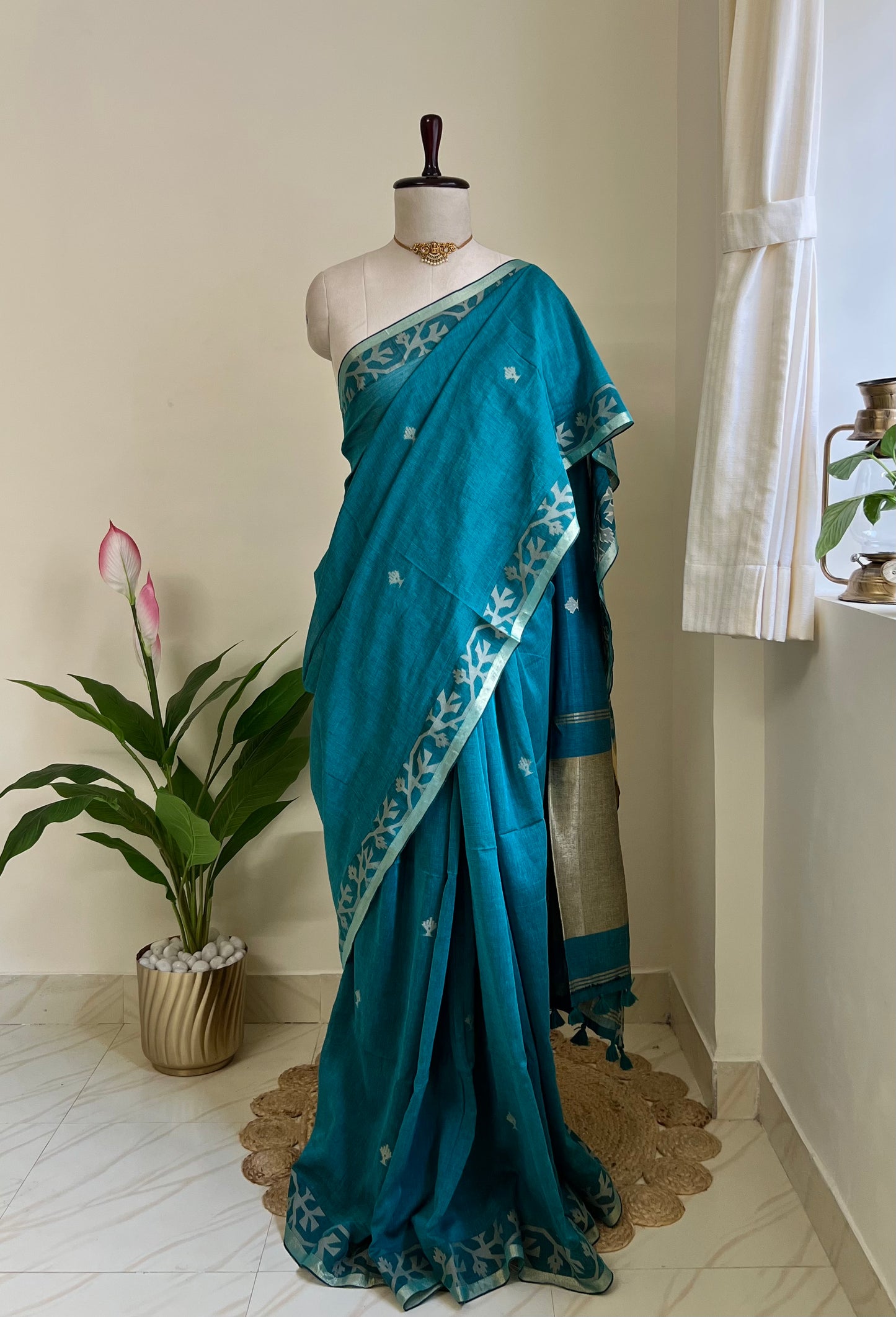 Peacock blue pure cotton jamdani saree with zari border and pallu, draped on mannequin