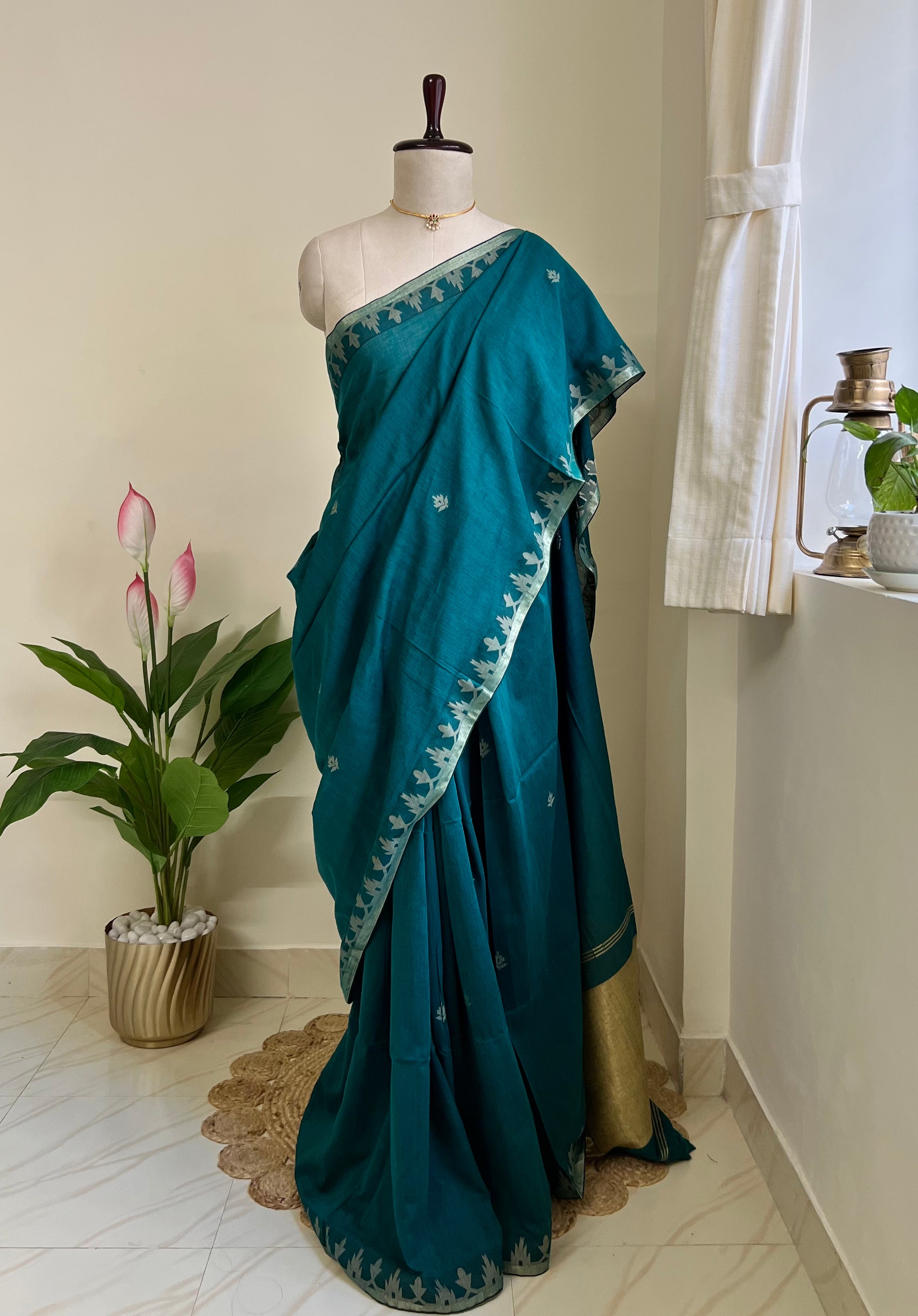 Deep teal pure cotton jamdani saree with zari border and pallu, draped on mannequin